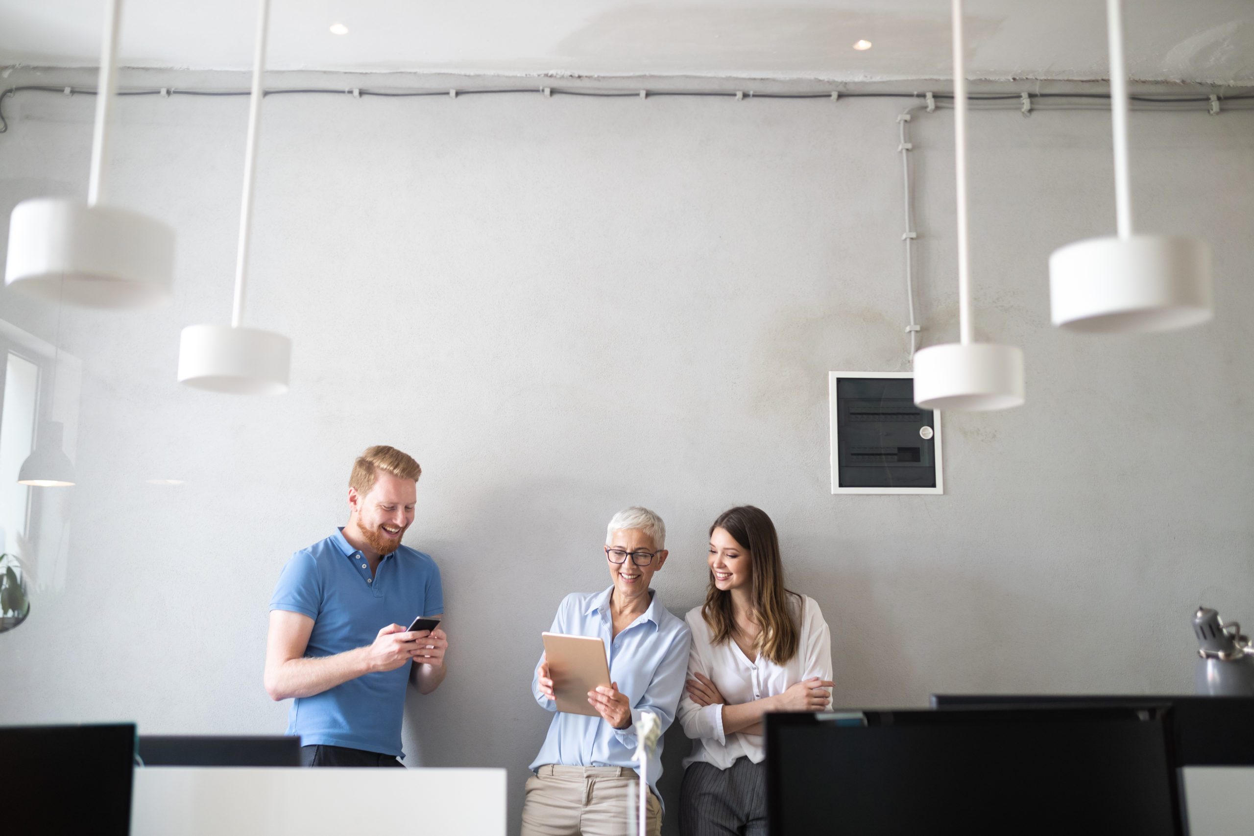 Man Using Phone And Woman Using A Tablet